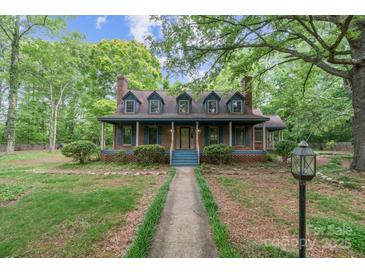 Charming two-story home with a cozy front porch, dormer windows, and a lush green lawn at 1513 Shelby Hwy, Cherryville, NC 28021