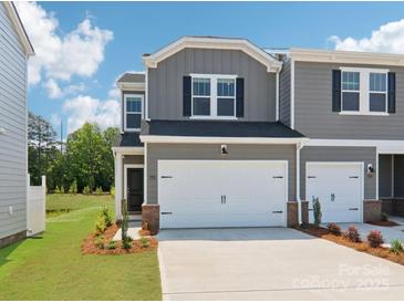 Two-story townhome with gray siding, black shutters, two car garage, and well-manicured landscaping at 1712 Braemar Village Dr, Monroe, NC 28110