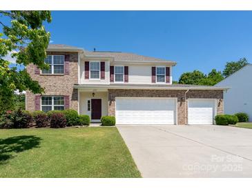 Charming brick and siding two-story home featuring a spacious three-car garage and well-manicured lawn at 4321 Tucker Chase Dr, Midland, NC 28107