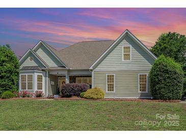 Charming one-story home features manicured lawn, mature landscaping, and welcoming covered front porch at 6603 Havencrest Dr, Denver, NC 28037