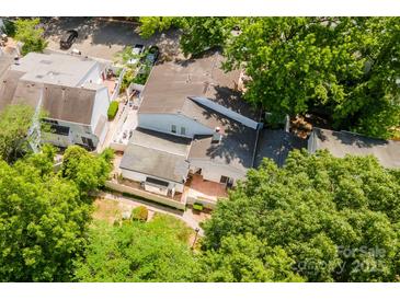 Aerial view showcases fenced backyard, red brick patio and mature shade trees at 7129 Stonington Ln, Charlotte, NC 28227