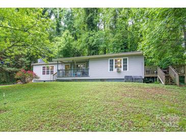 Charming ranch home featuring a cozy porch, a small set of stairs, surrounded by lush greenery and a well-maintained lawn at 857 Hills Rd, Belmont, NC 28012
