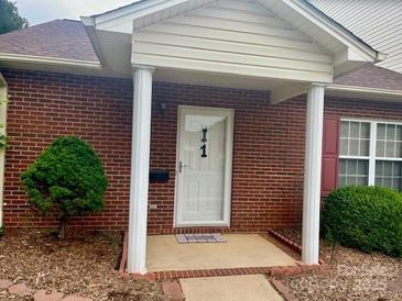 Charming brick home featuring a covered front entrance with stately white columns and a well-manicured lawn at 102 Brandywine Ne Dr # I-1, Conover, NC 28613