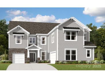Charming two-story home featuring a combination of stone and siding, complemented by manicured landscaping and attached garages at 12128 Avast Dr, Huntersville, NC 28078
