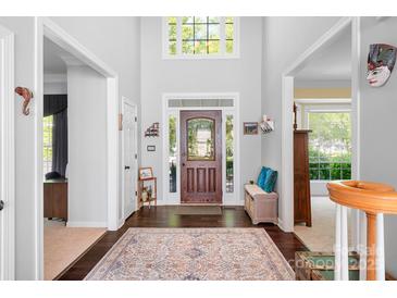 Inviting foyer with dark hardwood floors, decorative rug, front door with transom window, and high ceilings at 16028 Hallaton Dr, Huntersville, NC 28078