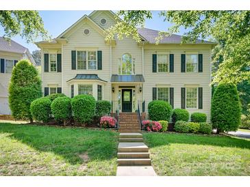 Charming two-story home with black shutters and a beautifully landscaped front yard at 16028 Hallaton Dr, Huntersville, NC 28078
