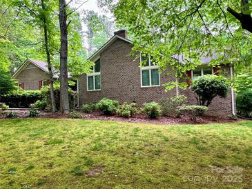 Charming brick home with well-maintained lawn, mature trees, and lush landscaping at 1623 Arbor Way, Albemarle, NC 28001