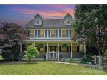 Charming two-story home with a inviting front porch, beautiful landscaping, and traditional design at 1687 Windy Hill Ln, Great Falls, SC 29055