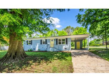 Charming blue home featuring a covered carport, freshly landscaped yard, and a sunny yellow front door at 2313 Eleanor Dr, Shelby, NC 28150