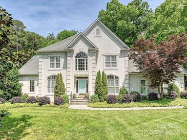 Charming home featuring manicured lawn, lush landscaping, and a stately facade with a pop of color at the front door at 4608 Morrowick Rd, Charlotte, NC 28226