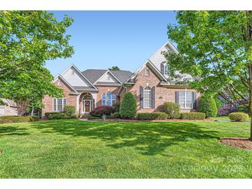 Beautiful brick home boasts lush lawn, manicured landscaping and mature trees at 534 Ballymote Ct, Matthews, NC 28104