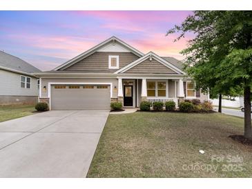 Charming single-Gathering home with a two-car garage, covered porch, and manicured lawn at 7113 Meridale Forest Dr, Charlotte, NC 28269
