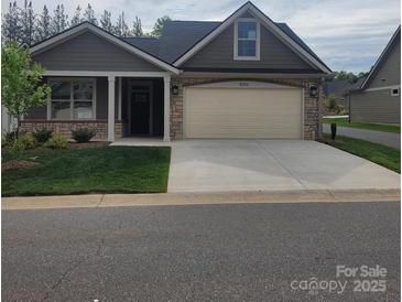 Charming one-story home featuring a well-manicured lawn, neutral exterior, and a two-car garage with stone accents at 835 A Wynnshire Dr # 53, Hickory, NC 28601