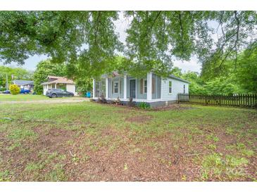 Charming home with light blue siding, a cozy screened-in porch, and a well-maintained yard at 917 Laye St, Belmont, NC 28012