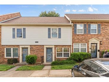 Charming townhouse with brick and siding exterior, featuring blue shutters and well-maintained landscaping at 1228 Archdale Dr # H, Charlotte, NC 28217