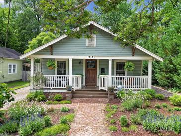 Charming home with a covered front porch, brick pathway, and lush landscaping at 1713 Allen St, Charlotte, NC 28205
