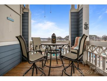 Outdoor seating area with four chairs, table and a view of the bay on a covered balcony at 18669 Vineyard Point Ln, Cornelius, NC 28031