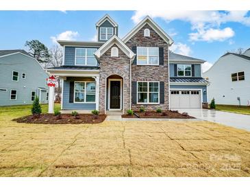 Charming two-story home featuring stone accents, a two-car garage, and beautifully landscaped front yard at 2011 Cedar Falls Dr # 71, Waxhaw, NC 28173