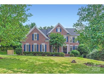 Traditional brick home featuring blue shutters and manicured landscaping at 2215 Maycroft Dr, Charlotte, NC 28262