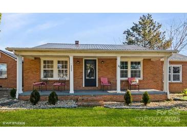 Charming single-story brick home with a cozy front porch and well-manicured landscaping at 303 Island Ford Rd, Maiden, NC 28650