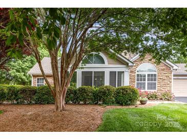 Charming home exterior featuring stone accents, manicured landscaping, and large windows at 9013 Trellis Pointe Blvd, Charlotte, NC 28227