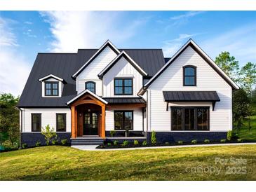 Stunning new construction featuring a black metal roof, white board and batten siding, and a welcoming wooden porch at 114 Wilharr Ct # 38, Mooresville, NC 28115