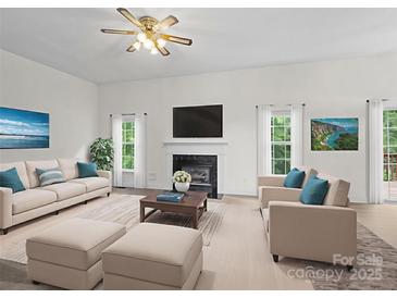 Bright living room features a decorative fireplace, plush seating, and modern decor at 12317 Panthersville Dr, Charlotte, NC 28269