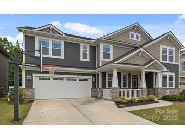 Charming two-story home with a two car garage, basketball hoop, landscaped yard, and covered front porch at 1601 Calder Dr, Indian Trail, NC 28079