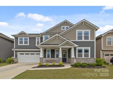 Charming two-story home with a welcoming front porch and well-manicured lawn in a lovely neighborhood at 1601 Calder Dr, Indian Trail, NC 28079