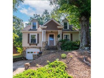 Charming home with stone accents, dormer windows, and a well-maintained yard and stairs to the entrance at 208 N 5Th St, Albemarle, NC 28001