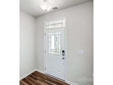 Bright foyer features a white front door with glass panes and wood flooring at 2405 Hedgecliff Rd, Kannapolis, NC 28025