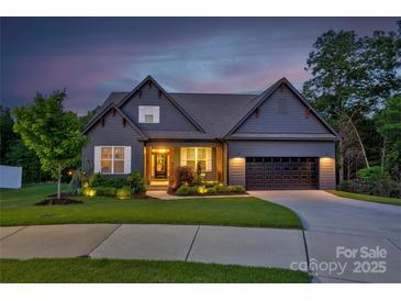 Charming home with a well-manicured lawn, a two-car garage, and inviting front porch at twilight at 3424 Saint Clair Nw Ct, Concord, NC 28027