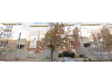 Attractive three-story townhome featuring brick accents, multiple windows, and well-maintained landscaping at 521 Donatello Ave, Charlotte, NC 28205