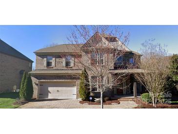 Charming two-story brick home featuring an attached two-car garage and well-maintained landscaping at 5633 Open Book Ln, Charlotte, NC 28270
