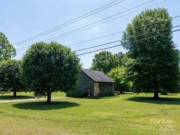 Charming home featuring green siding, stone accents, and a well-maintained lawn at 7728 Babe Stillwell Farm Rd, Huntersville, NC 28078