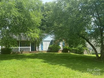 Charming single-story home with inviting front porch and lush, green lawn, shaded by mature trees at 8122 Cadmium Ct, Charlotte, NC 28215