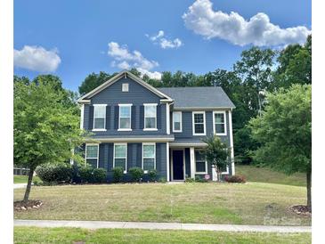 Two-story home featuring a well-manicured lawn and beautiful blue siding at 8268 Breton Way, Harrisburg, NC 28075