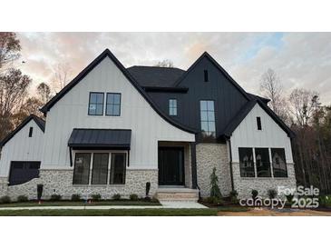 Stunning new construction home with a modern farmhouse exterior and stone accents at 136 Castleview Ln, Mooresville, NC 28115