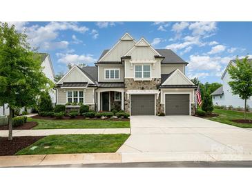 Charming two-story home features stone accents, a two-car garage, and manicured landscaping at 13602 Huntson Park Ln, Huntersville, NC 28078