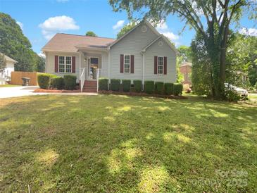Charming single-story home with well-manicured lawn, tidy shrubbery and brick steps leading to a cozy front porch at 211 Sherwood Cir, Rock Hill, SC 29730
