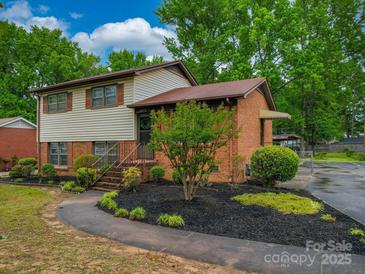 Charming two-story home with brick and siding, complemented by lush landscaping and a welcoming walkway at 2213 Milton Rd, Charlotte, NC 28215