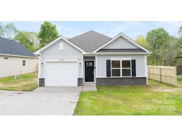 Charming one-story home with light gray siding, black shutters, and a one-car garage at 401 Groves St, Lowell, NC 28098
