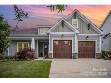 Charming home with a two-car garage, manicured lawn, and inviting curb appeal against a colorful sunset sky at 4016 Spring Cove Way, Belmont, NC 28012