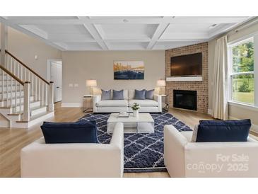 Inviting living room with a coffered ceiling, fireplace, and stylish furniture at 709 Cavesson Way, Monroe, NC 28110
