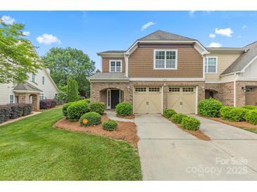 Charming townhouse with a two-car garage, landscaped front yard, and covered entryway, offering curb appeal at 8505 Loxton Cir, Charlotte, NC 28214