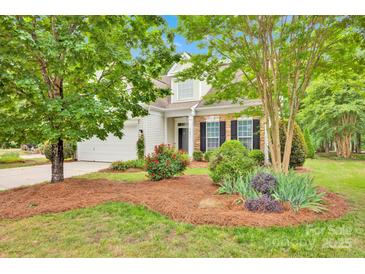 Charming two-story home with stone accents, a well-manicured lawn, and a beautifully landscaped front yard at 8938 Kestral Ridge Dr, Charlotte, NC 28269