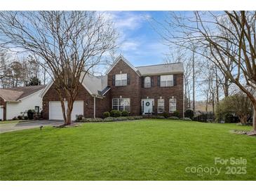 Charming two-story brick home with a well-manicured lawn and a welcoming light blue front door at 104 Steamboat Dr, Mount Holly, NC 28120