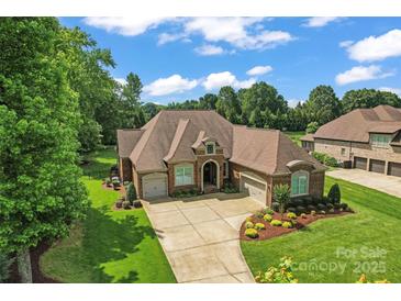 Stunning brick home with a three-car garage, professional landscaping, and a spacious driveway at 1400 Delaney Dr, Matthews, NC 28104