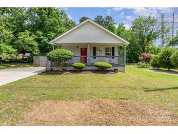 Charming single-story home with a welcoming porch, red front door, and well-maintained front yard at 201 Easy St, Concord, NC 28027