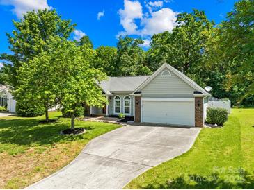 Charming single-story home with mature trees, well-manicured lawn, and two car garage at 3006 Emerald Meadow Ln, Charlotte, NC 28273
